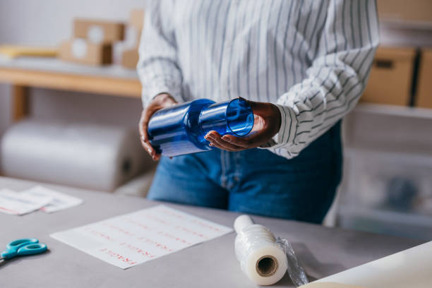 Person Packaging a Blue Glass Cup with Fragile Stickers and bubble pack