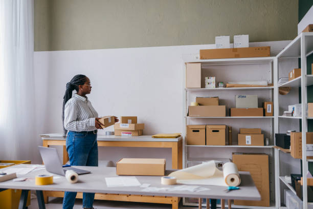 istock Young Woman Organizing Packages in a Home Office Workspace 2189160054