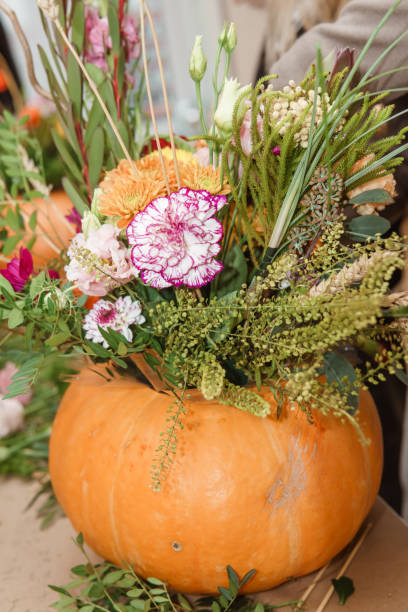 istock Flower arrangement in a pumpkin, autumn interior decor. Creating handmade autumn decor. 2189162383