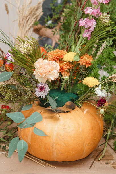 istock Flower arrangement in a pumpkin, autumn interior decor. Creating handmade autumn decor. 2189162388
