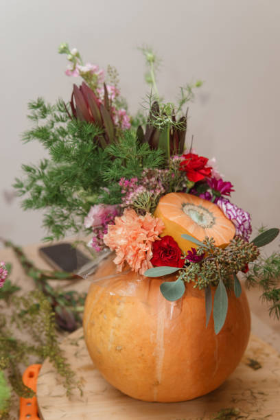 istock Flower arrangement in a pumpkin, autumn interior decor. Creating handmade autumn decor. 2189162391