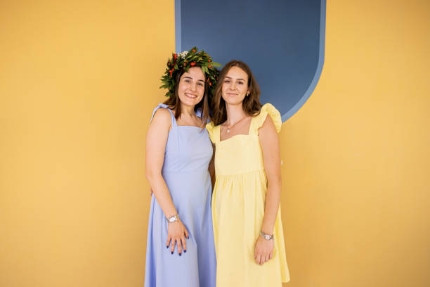 Two sisters sharing a heartwarming moment on graduation day, embracing and smiling lively