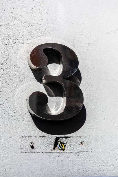 istock Stainless steel number three 3 on a modern concrete facade with a construction crack 2189164302