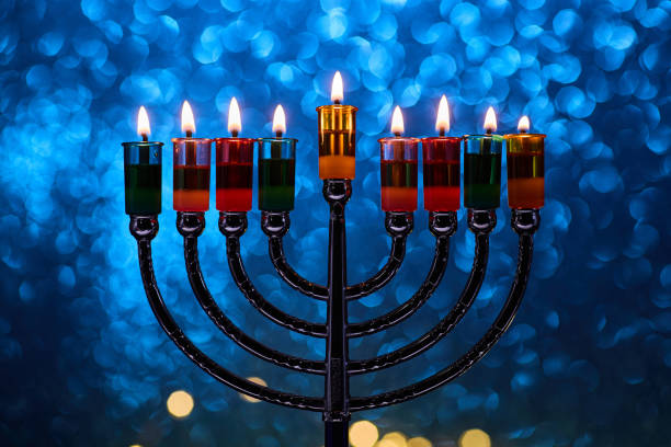 istock Hanukkah Menorah with burning candles on dark background with bokeh lights. 2189165234