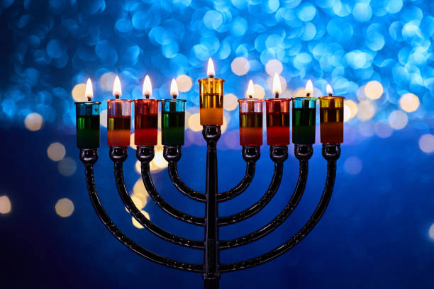 istock Hanukkah Menorah with burning candles on dark background with bokeh lights. 2189165239