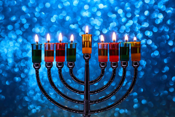 istock Hanukkah Menorah with burning candles on dark background with bokeh lights. 2189166222