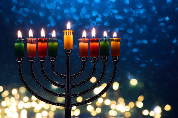 istock Hanukkah Menorah with burning candles on dark background with bokeh lights. 2189166617