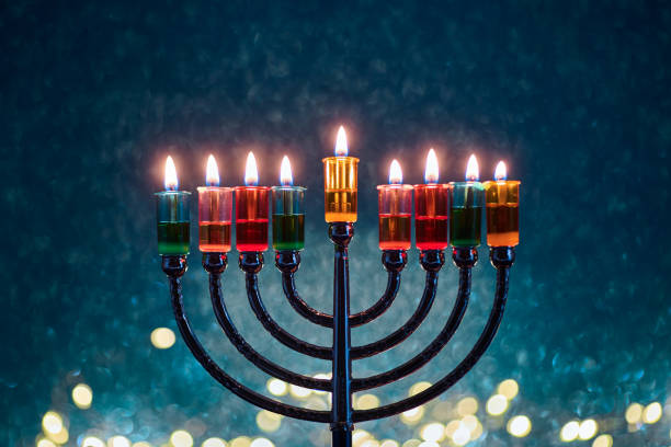 istock Hanukkah Menorah with burning candles on dark background with bokeh lights. 2189166689