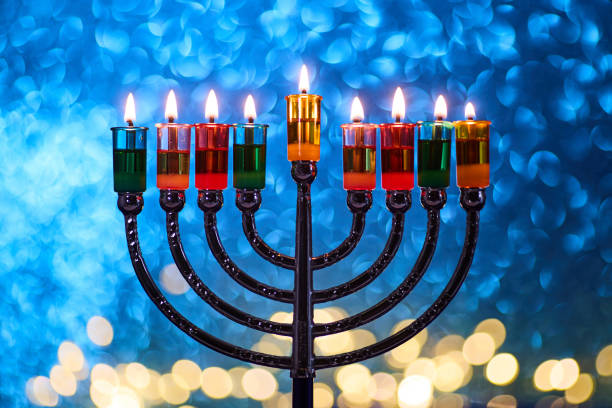 istock Hanukkah Menorah with burning candles on dark background with bokeh lights. 2189166854