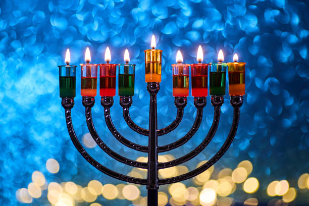 istock Hanukkah Menorah with burning candles on dark background with bokeh lights. 2189167272