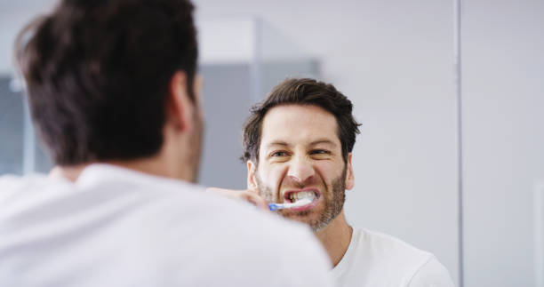 istock Toothpaste, bathroom and man brushing teeth for dental health, wellness and morning routine. Oral care, hygiene and male person with treatment for gum disease, cavity or plaque prevention in home. 2189167477