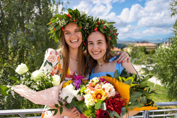 istock Embracing graduates with laurel wreaths  and bouquets 2189167881