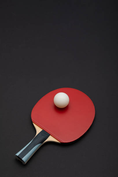 istock Professional Red Table Tennis Paddle with White Ball on Dark Background 2189171509