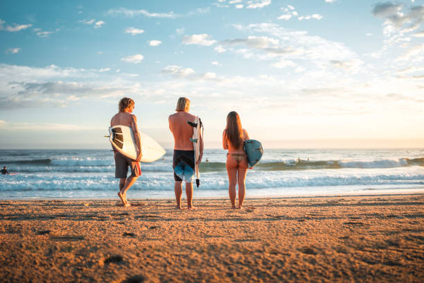 istock Caucasian Surfing Friends Enjoying Waves at Sunrise 2189171862