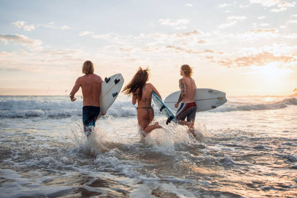 istock Excited Caucasian Surfers Running into Waves at Sunrise 2189171873