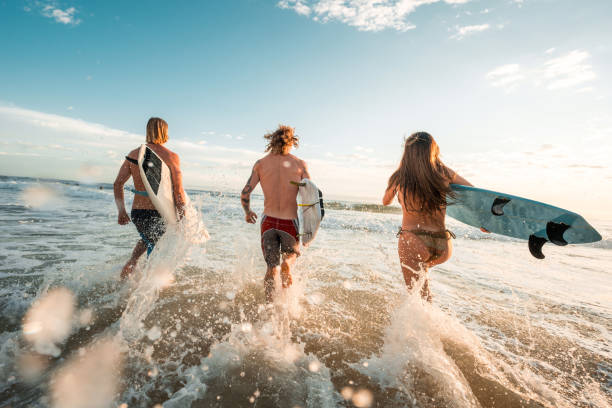 istock Caucasian Friends Joyfully Surfing at Sunrise 2189171885