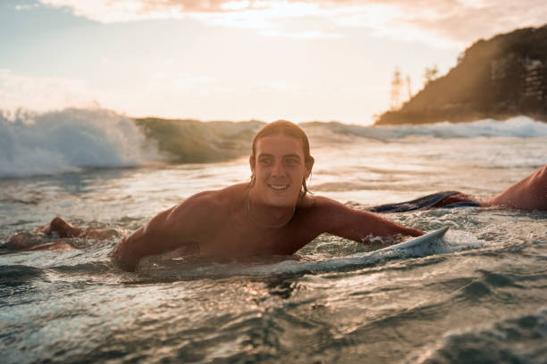 Caucasian Male Surfer Joyfully Riding Ocean Waves at Sunrise
