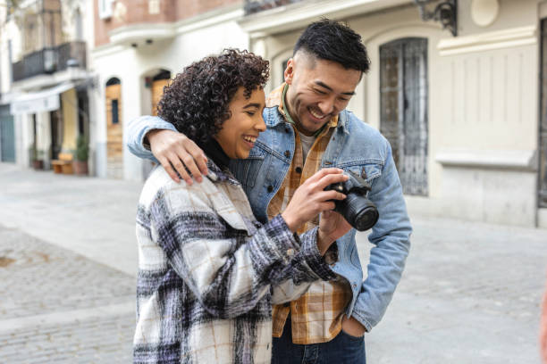 istock Happy multiracial couple taking pictures outdoors with digital camera 2189172217