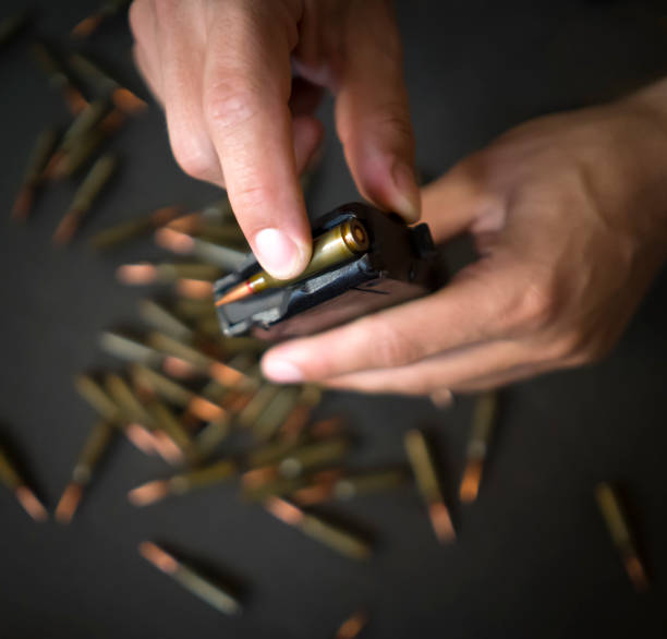 istock Hands with 5.45 caliber cartridges for weapon closeup. 2189175047