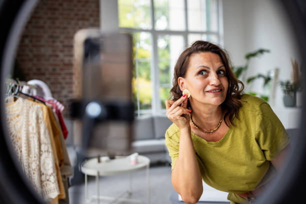 istock Woman Applying Earrings in Bright Interior Setting 2189176203