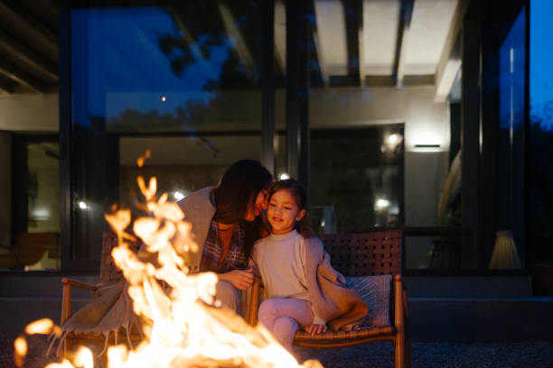 istock Mother and daughter bonding by the fire at dusk 2189177780