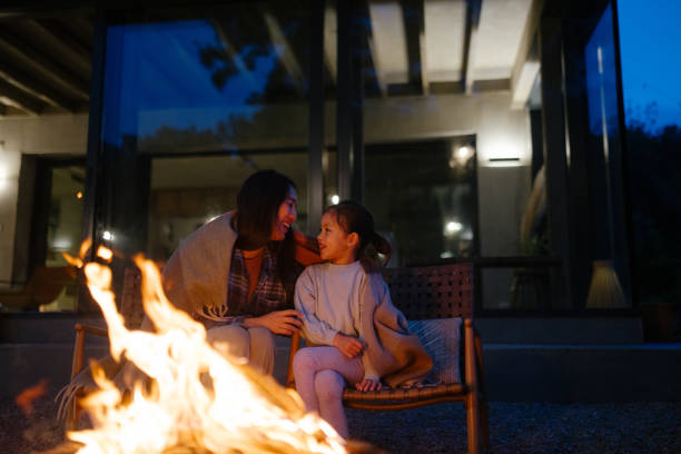 istock Mother and daughter bonding by the fire at dusk 2189177817