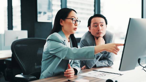 istock Meeting, manager and Asian business people on computer with feedback, review and help for online project. Office, corporate and worker with boss for teamwork, collaboration and discussion in Japan 2189178140