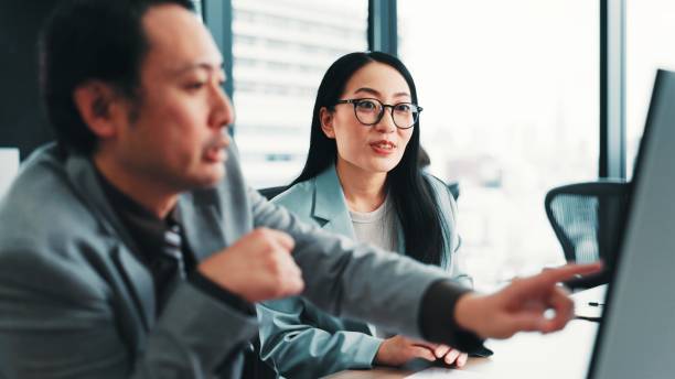 istock Help, manager and Asian business people on computer with feedback, review and meeting for online project. Office, corporate and worker with boss for teamwork, collaboration and discussion in Japan 2189178158
