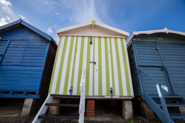 bathing huts at the sea in green color. booths for changing clothes during the summer season on beach holidays. changing rooms arranged in a regular and orderly row