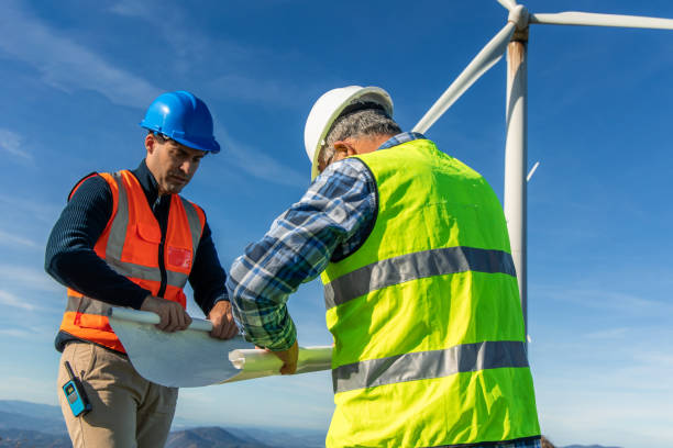 istock Engineers examining blueprint at wind turbine site 2189180359
