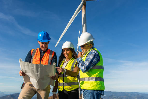 istock Engineers examining blueprint at wind turbine site 2189180532