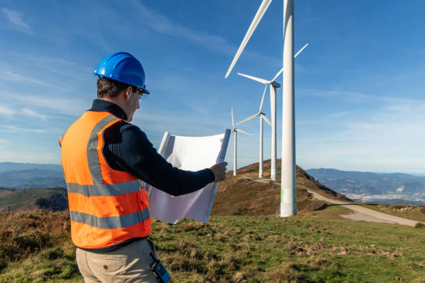 istock Engineer examining blueprint at wind turbine site for green energy 2189180901