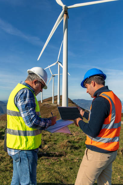 istock Engineers inspecting wind turbines for green energy production 2189180913