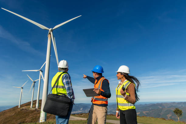 istock Engineers maintaining modern wind turbines in rural landscape 2189181339