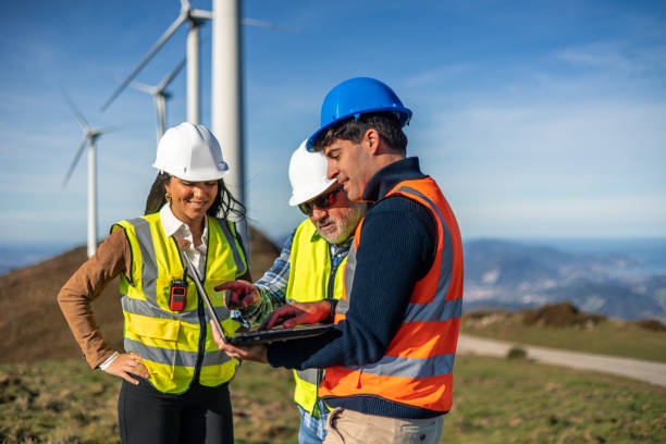 istock Engineers working on a laptop in front of wind turbines 2189181434