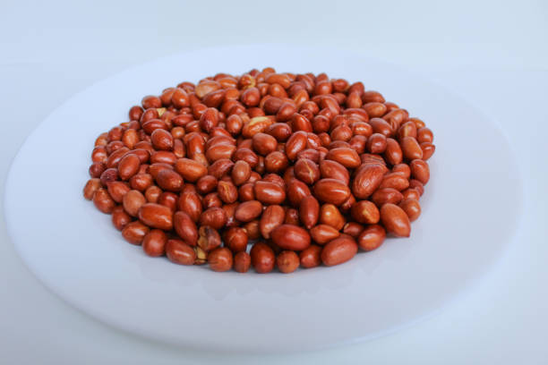 Fried groundnut, Goober or Monkey Nut, or Arachis hypogaea. On a white plate, isolated on white background