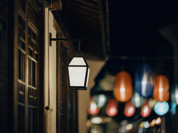 A traditional Chinese lantern illuminates a dimly lit street, creating a warm and inviting atmosphere. The image captures the charm and beauty of traditional Chinese architecture and culture.