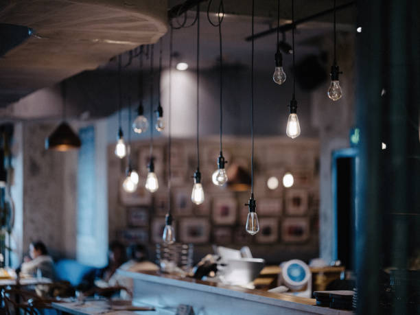 istock A cozy cafe interior with a cluster of Edison bulbs hanging from the ceiling, casting a warm and inviting glow. 2189188746