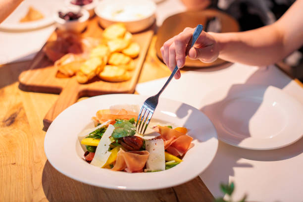 istock salad with assorted greens, mango, and cured meats served in a white bowl 2189189300