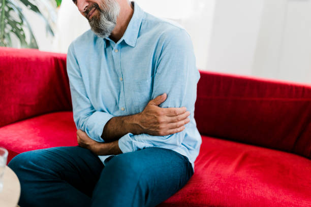 istock Senior man feeling unwell, suffering from backache, massaging aching muscles while sitting on sofa in the living room at home. Elderly and health issues concept 2189190258