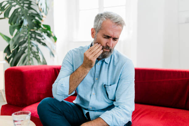 istock Senior man feeling unwell, suffering from backache, massaging aching muscles while sitting on sofa in the living room at home. Elderly and health issues concept 2189190427