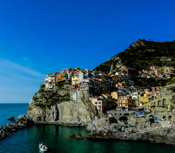 A beautiful blue ocean with a small town in the background. The town is full of colorful buildings and has a peaceful atmosphere