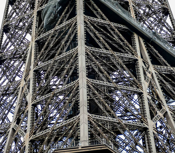 The Eiffel Tower is a large, intricate structure with many metal beams and wires. Concept of awe and wonder at the engineering feat that is the Eiffel Tower