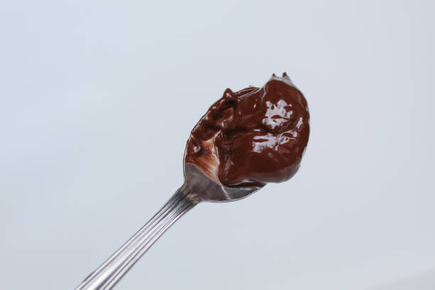 istock One spoon of melted dark chocolate, or chocolate spread, isolated on white background 2189191764