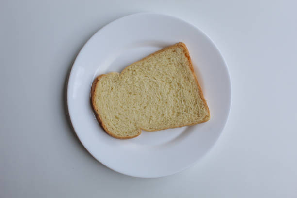 istock One slice of white bread, on white plate, isolated on white background, flat lay or top view 2189191849