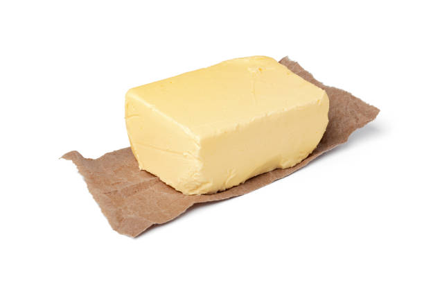 Fresh butter on craft paper isolated on white background, close up.