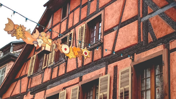 Charming half-timbered gingerbread house adorned with decorations in a quaint village during festive season, Ribeauville, Alsace, France