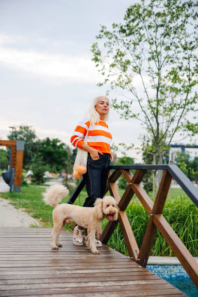 istock Walking time in the park for red poodle and her owner 2189196138