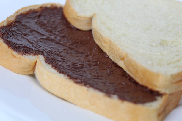 istock Two slices of white bread with chocolate spread or chocolate jam. Chocolate sandwich. On white plate, isolated on white background 2189197978