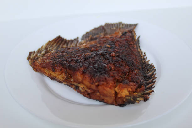 istock Grilled gourami fish tail, on a white plate, isolated on white background 2189199090